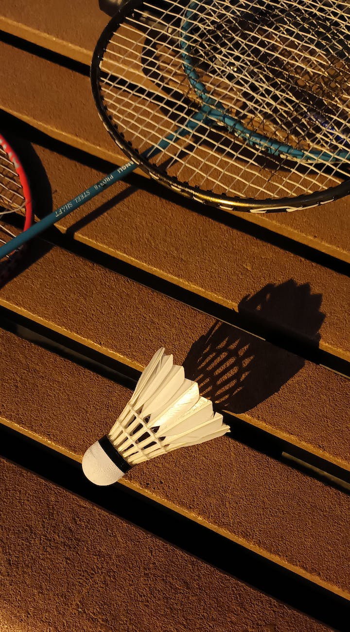 shuttlecock and badminton rackets on a wooden surface