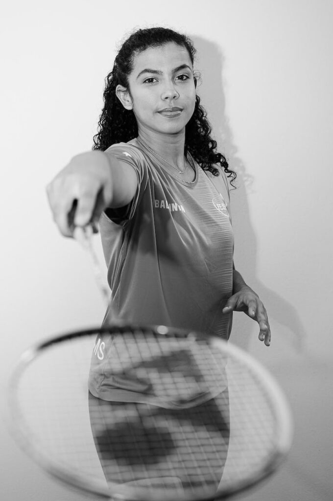 grayscale photo of woman holding badminton racket