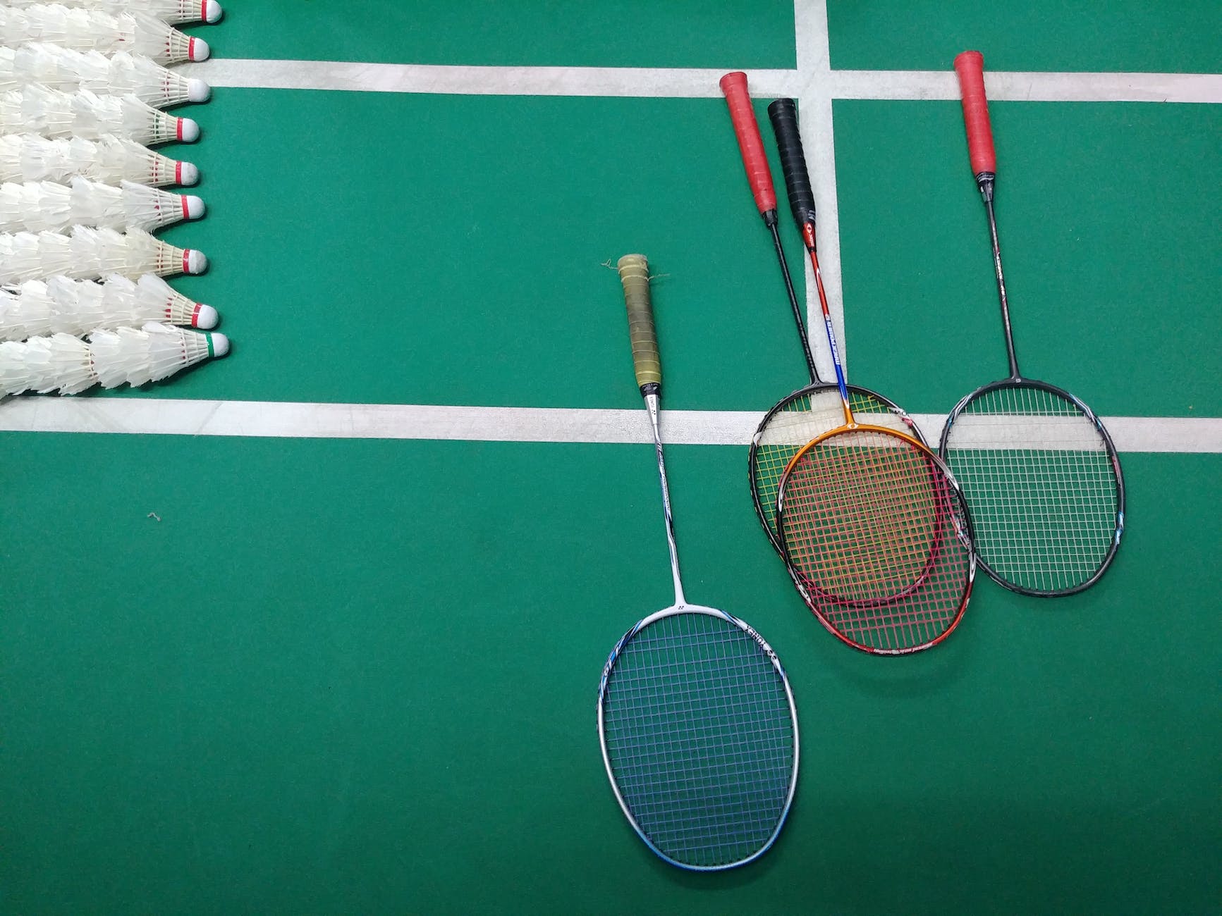 green and white court with badminton rackets