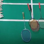 green and white court with badminton rackets