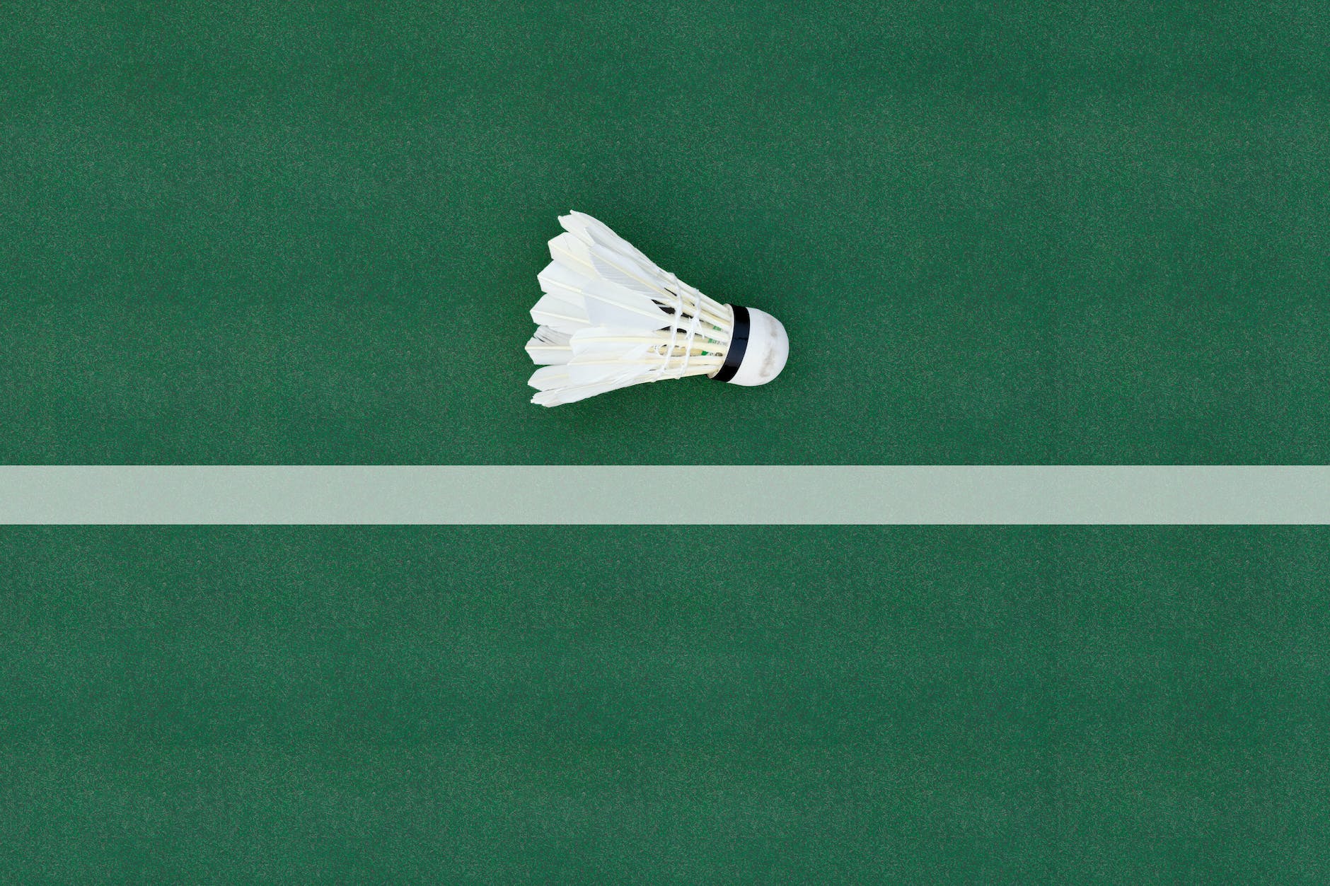 a close up shot of a shuttlecock on a badminton court floor