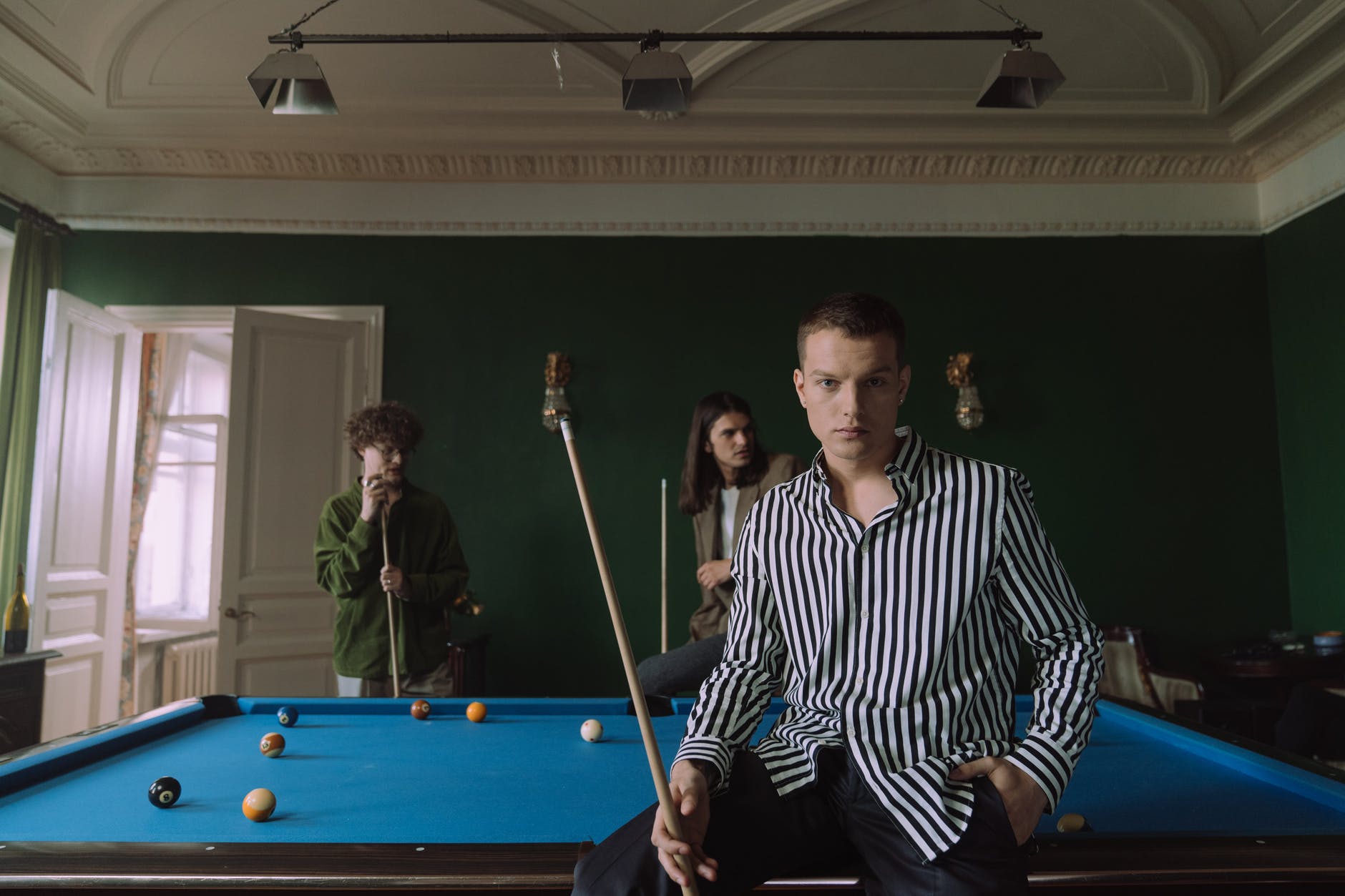 man in black and white striped long sleeve shirt standing beside man in black and white